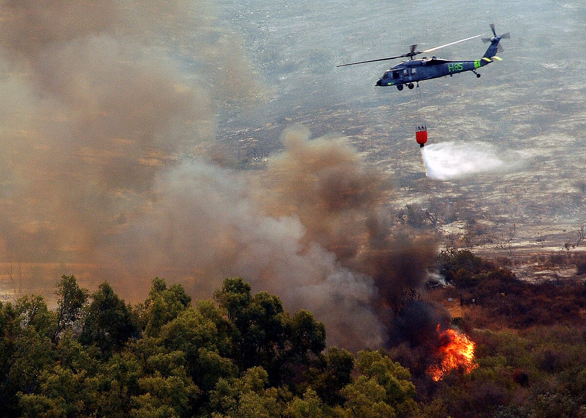 1200px-US_Navy_drops_water_from_a_helicopter-borne_firefighting_bucket.jpg